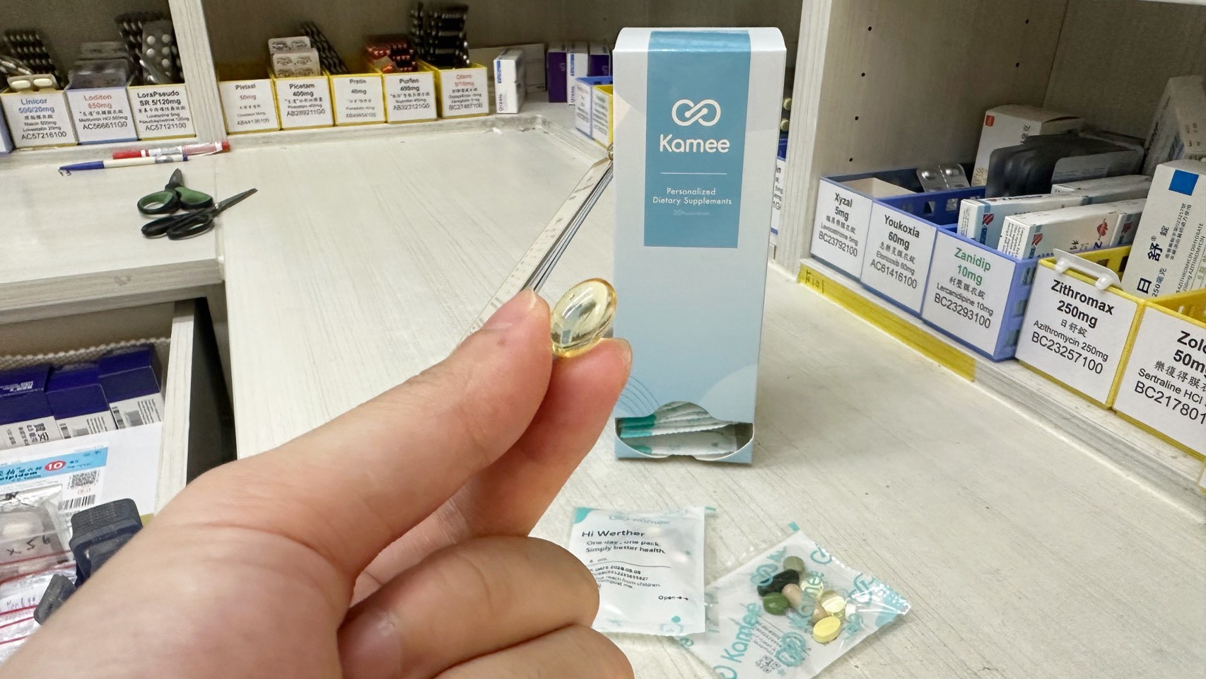 維特藥師手持咖米保健食品膠囊，桌上擺放咖米個人化保健食品包裝與每日營養包。